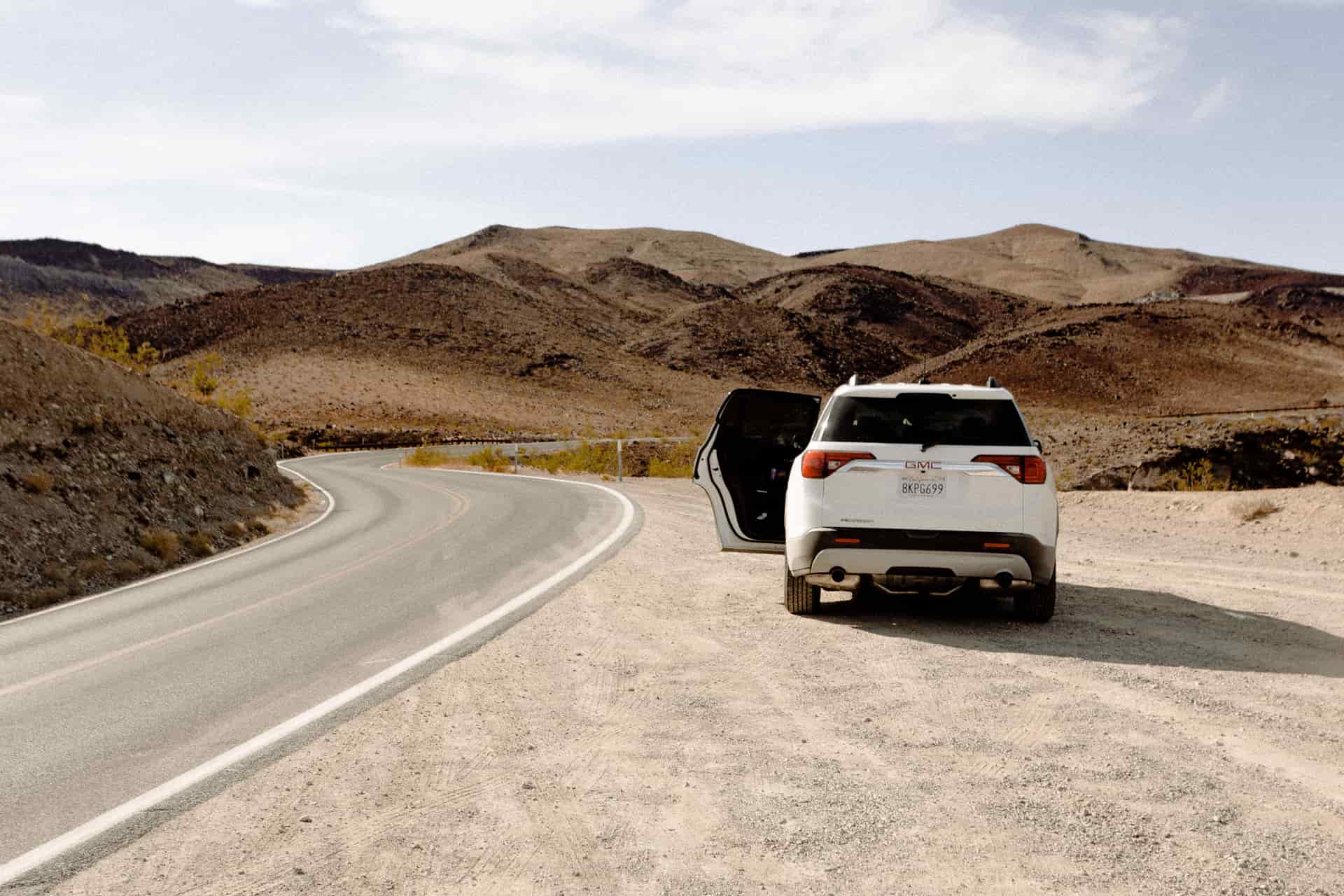 A car parked beside an empty desert highway